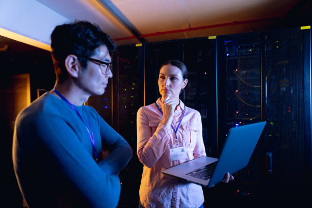 istock Diverse male and female engineers using laptop in computer server room 1352918346