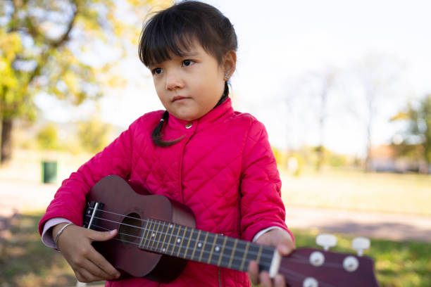 istock A girl playing with a toy guitar 1352918546