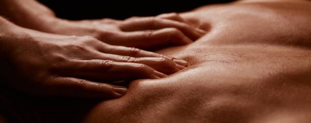 Hands of a girl on a tanned male back close-up. Horizontal banner stock photo