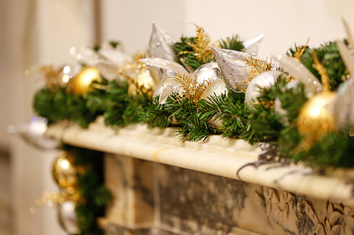 Christmas garland is seen on fireplace