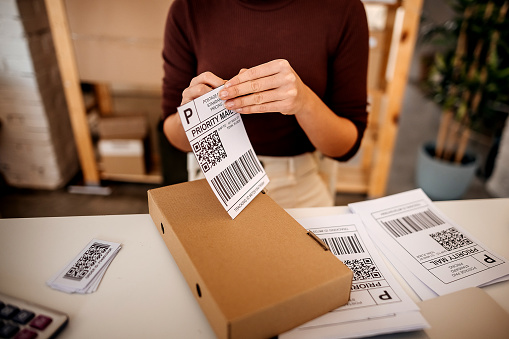 Woman prepares packages for sending in her warehouse
