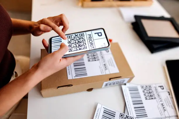 Photo of Businesswoman reading the bar code with the mobile phone app