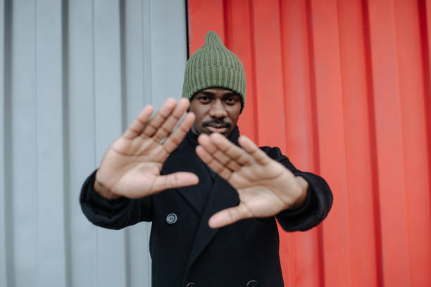 istock Insistend black man in a warm autumn coat blocking camera with his hands 1352927568