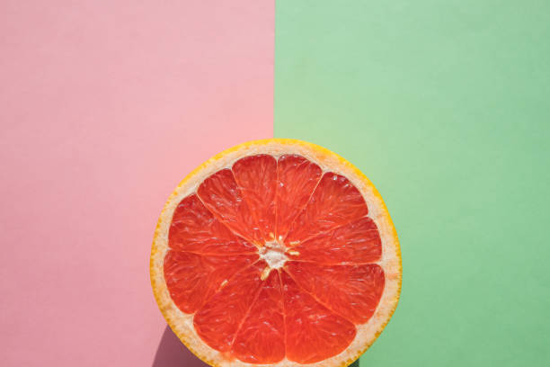 cut grapefruit.Slice of ripe grapefruit ..fruit Ready to Eat pomelo cortado en macro, tropical creativo concepto de fruta de comida mínima, sobre fondo verde rosa. rebanada de pomelo maduro.fruta lista para comer.cítricos frutas frescas.desintoxicación, vitamina, nutrición para el cuidado de la salud