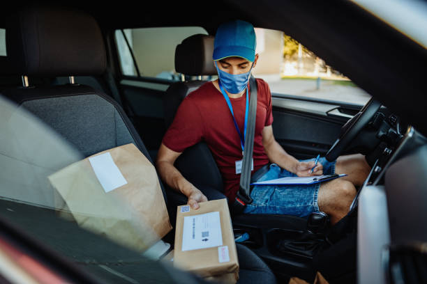 istock Delivery man with face mask in vehicle with parcels 1352929069