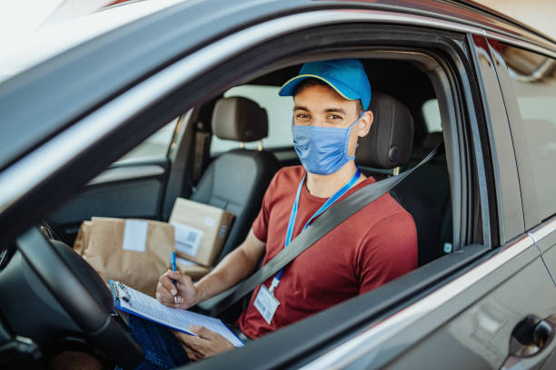 istock Delivery man with face mask in vehicle with parcels 1352929095