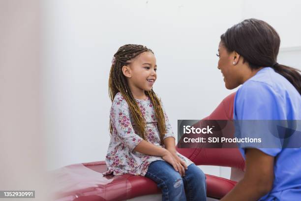 Dental Hygienist Talks With Young Pediatric Patient Stock Photo - Download Image Now