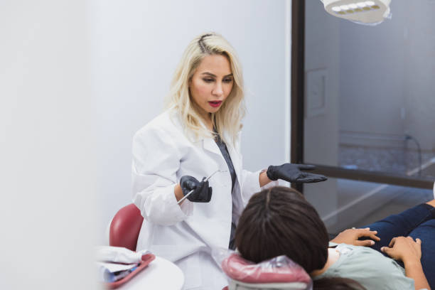 istock Dentist talks with patient during dental exam 1352931016