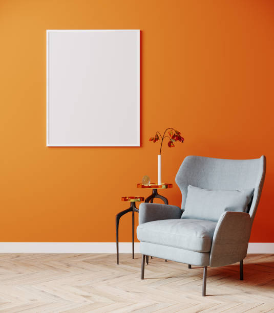istock Blank vertical frame mock up in modern interior background with bright orange wall, gray armchair and coffee table on wooden floor, 3d rendering 1352931530