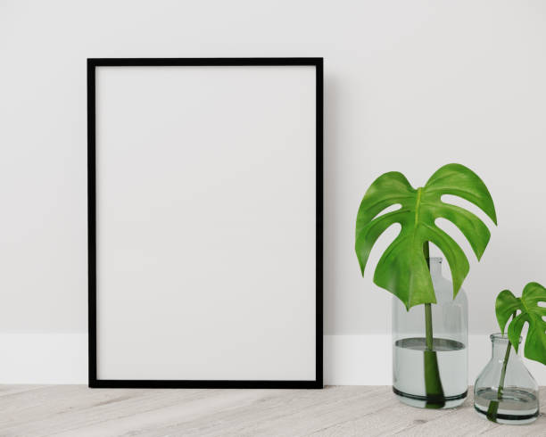 istock Blank vertical black poster frame standing on light wooden floor with next to white wall. Blank poster frame mockup. Empty picture frame mockup. Vertical frame mock up. Blank photo frame. 3d rendering 1352931534