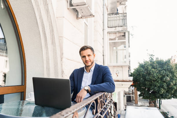 istock Handsome man with cup of coffee is working online using laptop in cafe. Remote work. 1352933874