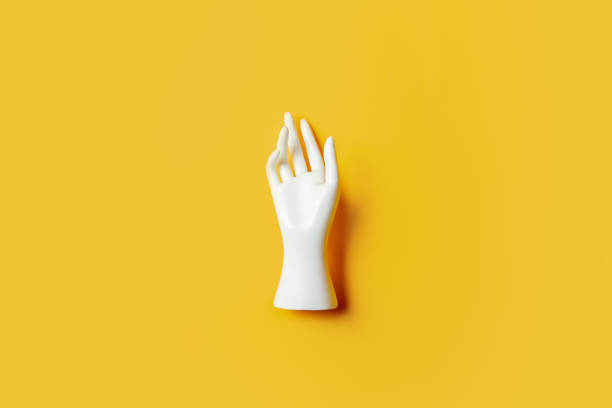 istock One white mannequin hand on yellow background. 1352940391