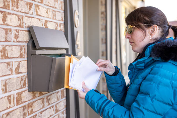 frau, die post zu hause in ihrem briefkasten in australien abholt - mailbox mail box side view stock-fotos und bilder