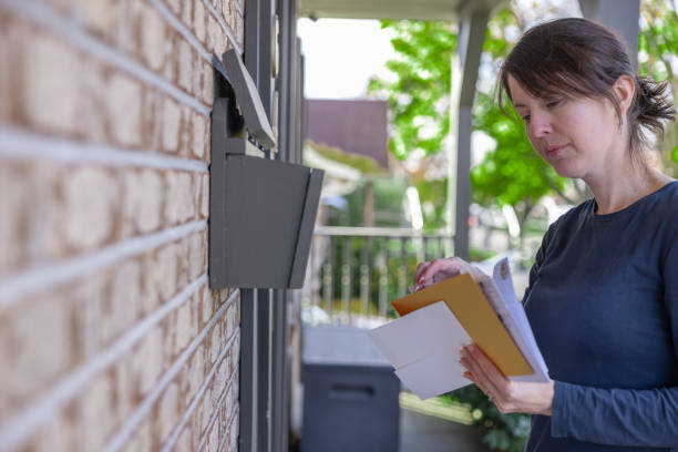 frau, die post zu hause in ihrem briefkasten in australien abholt - mailbox mail box side view stock-fotos und bilder