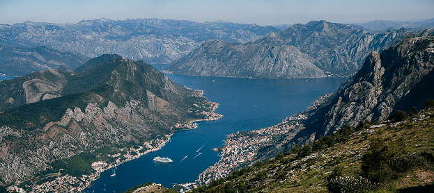 Cruise ship is located in the Kotor Bay against the backdrop of mountains. Lovcen, Montenegro. High quality photo