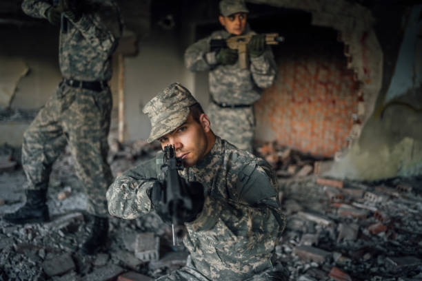 istock Young soldier looking into gun sight and aiming 1352944094