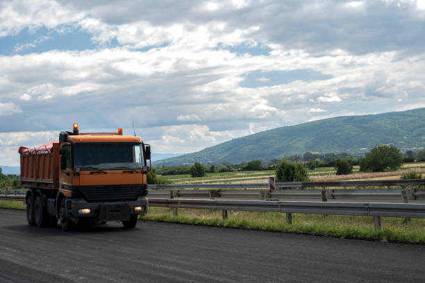 istock A large and heavy dump truck is parked on the highway. 1352947138