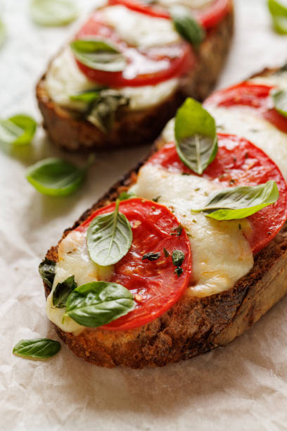 sandwich caprese grillé à base de pain au levain avec ajout de tomates, de fromage mozzarella, de basilic frais et d’huile d’olive - bruschetta tomato bread mozzarella photos et images de collection