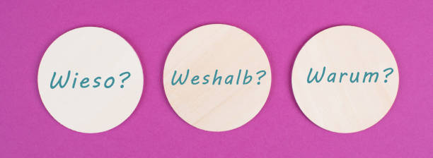 The german words for why are standing on circels, pink colored background, asking questions stock photo