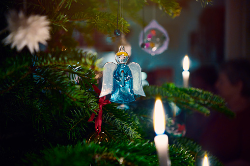 Christmas decoration on Christmas tree. Blue angle and Christmas candle lights
