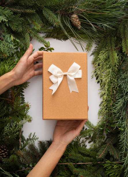 istock Homemade white copyspace and conifer brunches and cones in corners beautifuly arranged flat lay do it yourself minimalism natural art with recyclable packaging gift with bow hands hold 1352951254