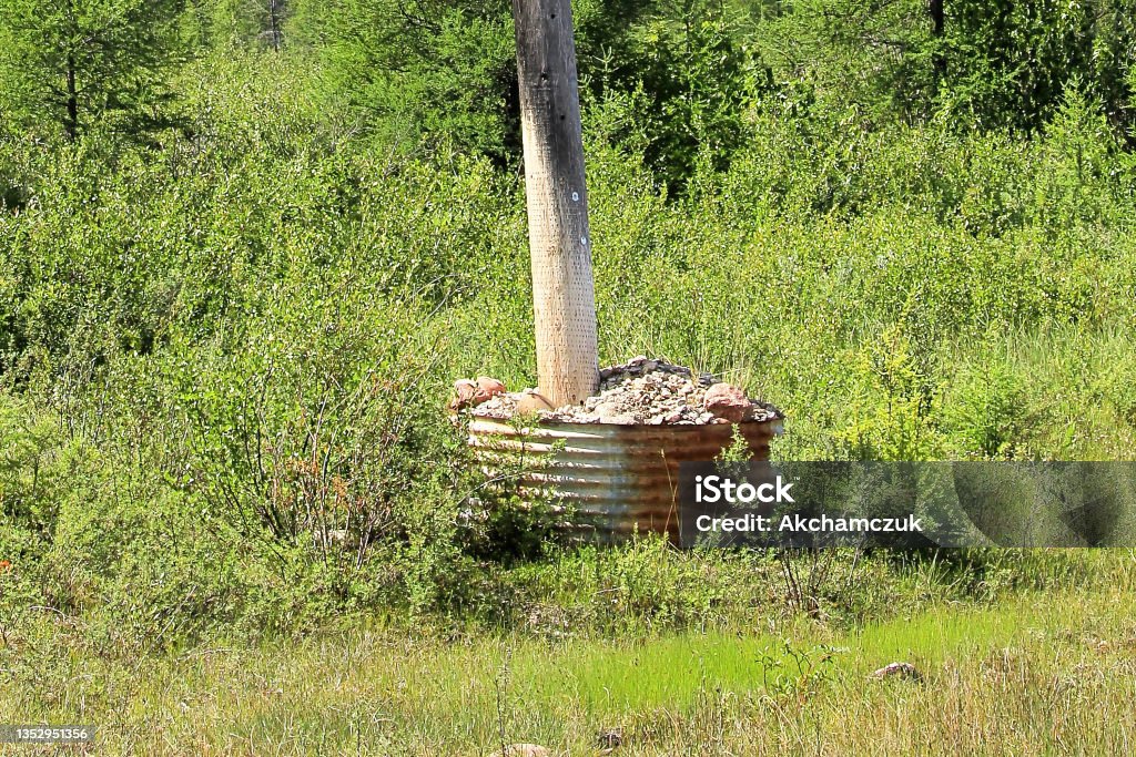 A powerpole stabalized and anchored by rocks A powerpole stabalized and anchored by rocks. Animal Pouch Stock Photo
