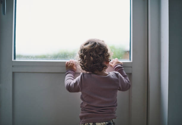istock Toddler looking out of window 1352952196