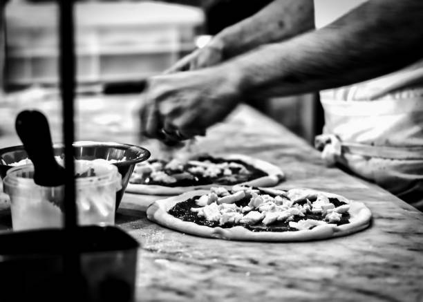 Oven Ready A chef making pizza bound for the wood fired oven at a pizzeria in Kamakura, Japan. italian food black and white photos stock pictures, royalty-free photos & images