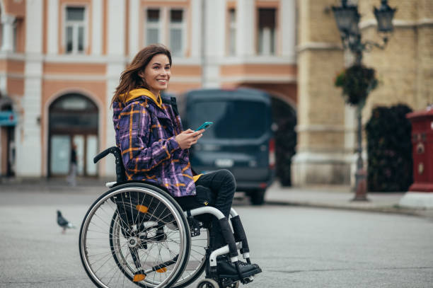 istock Woman with disability using a smartphone while out in the city 1352960114