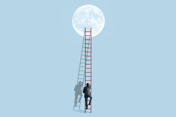 istock Man Uses A Tall Ladder To Climb To The Moon 1352964323