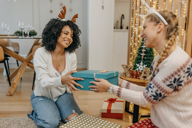 istock Two friends exchange Christmas presents 1352964931