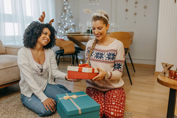 istock Two friends exchange Christmas presents 1352965044