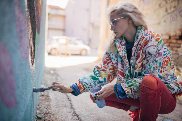 istock Female artist painting on wall 1352967943