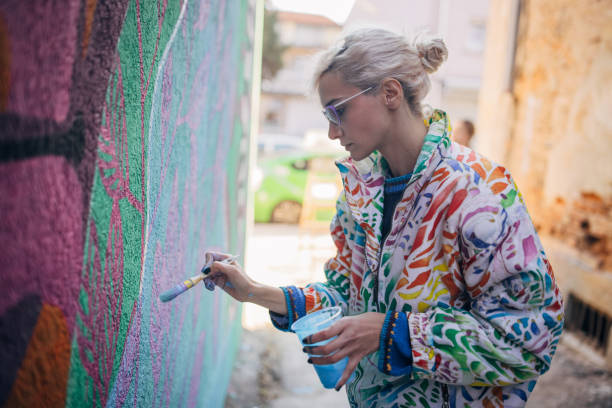 istock Female artist painting on wall 1352967974
