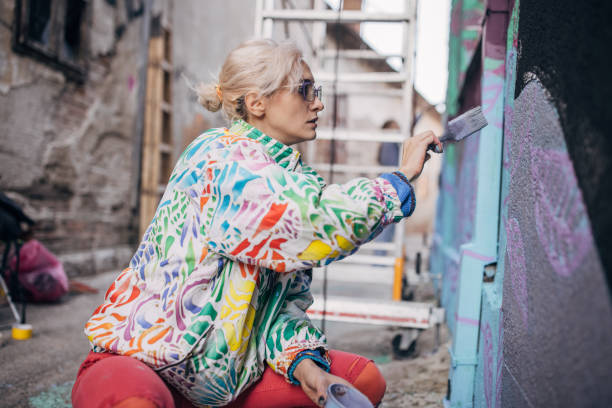 istock Female artist painting on wall 1352967984