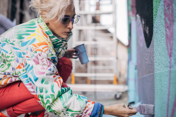 istock Female artist painting on wall 1352968106