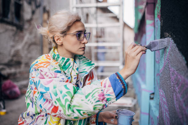 istock Female artist painting on wall 1352968139