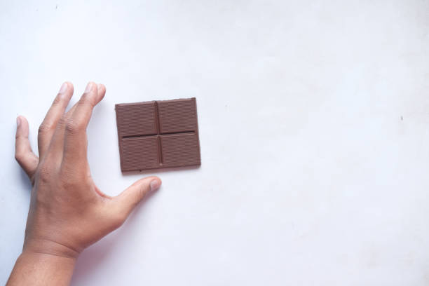 istock hand pick dark chocolate on a plate on table close up 1352976249