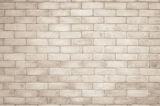 istock Cream and white brick wall texture background. Brickwork and stonework flooring interior rock old pattern clean concrete grid uneven bricks design stack. Background of old vintage brick wall 1352978530