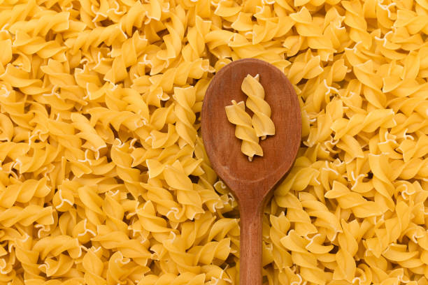 istock Uncooked Fusilli Pasta with Wooden Spoon 1352987756