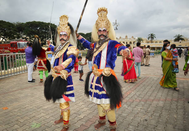 artistas folclóricos vestidos con coloridos trajes de época del señor shiva dios posan para una fotografía sincera durante el festival dasara en mysore, india. - mysore fotografías e imágenes de stock