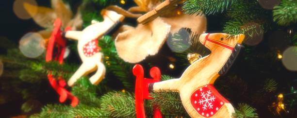 New year and christmas 2022 banner. Toy horses on a Christmas tree with a garland stock photo