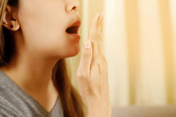 Asian woman checking her breath with hand test. Health Care concept. stock photo