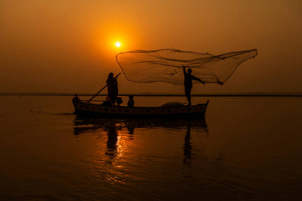 istock fisher man with net in the air 1352996195