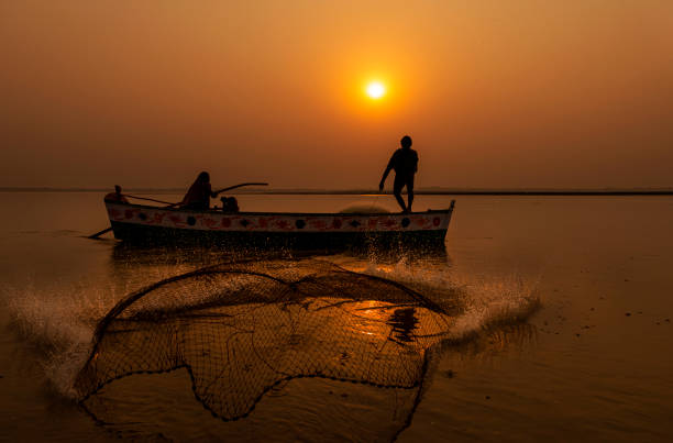 istock fisher man with net in the air 1352996254