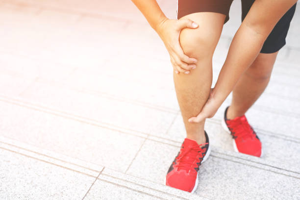 corridore che tocca doloroso contorto o rotto. allenamento dell'atleta, corsa su e giù per le scale incidente. la distorsione sportiva slogata causa lesioni al ginocchio. e dolore con le ossa delle gambe - stairway to hell foto e immagini stock