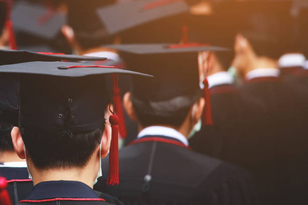 istock Group of Graduates during commencement stand in row. Concept education congratulation in University. Graduation Ceremony. copy space banner. 1352996316
