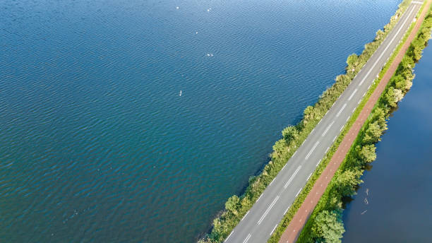 vista aérea con drones de la carretera de la autopista y la ruta ciclista en la presa de pólder, tráfico de automóviles desde arriba, holanda del norte, países bajos - netherlands dyke polder aerial view fotografías e imágenes de stock