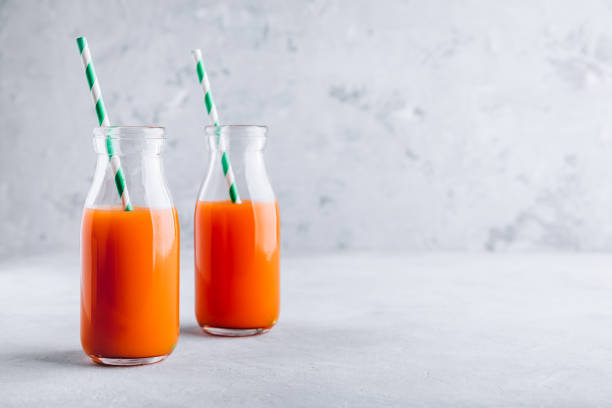 suco de cenoura. suco de cenoura desintoxicação orgânica fresco em garrafas de vidro - apple red fruit water - fotografias e filmes do acervo