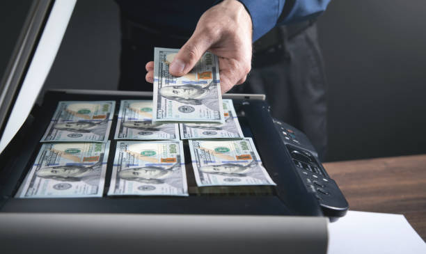 istock Man copying a money on a copy machine. 1353005409